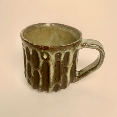 Taza pasta negra expuesta con bajorelieve en bandas anchas y ovalos alineados. Celeste WZ